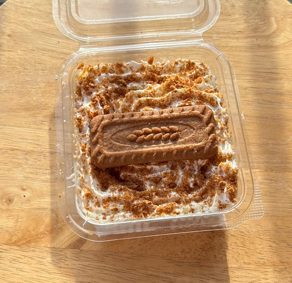 Twins Milkcakes Classic Biscoff milkcake in a clear square tub, soaked sponge and cream layers topped with crushed Lotus Biscoff and a whole biscuit